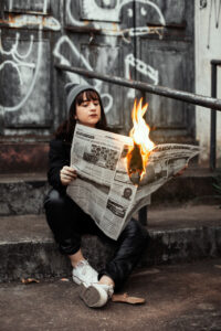 Κοπέλα με εφημερίδα που έχει πάρει φωτιά